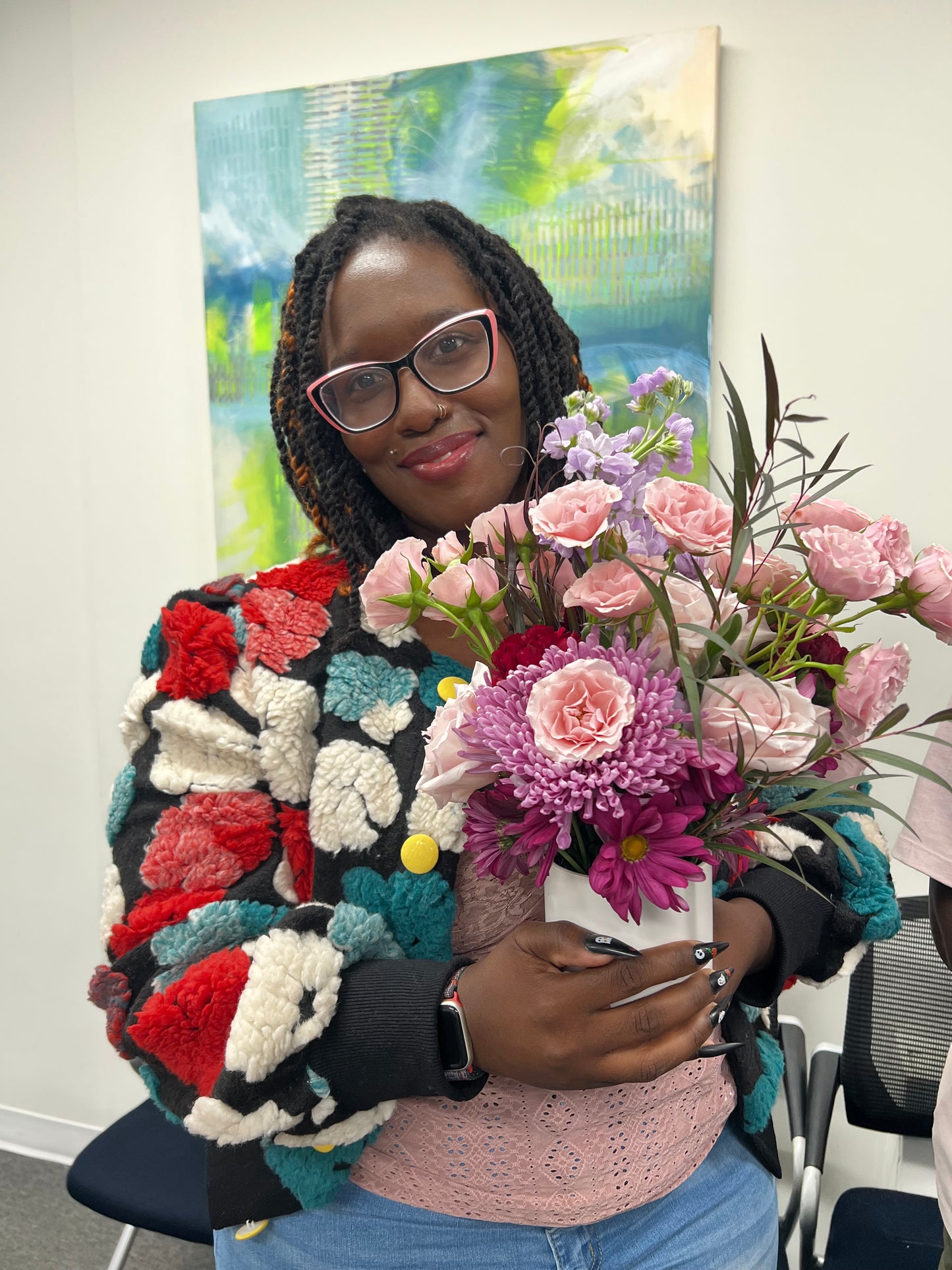 Person wearing a colorful sweater with flowers on their head, sitting in a car.