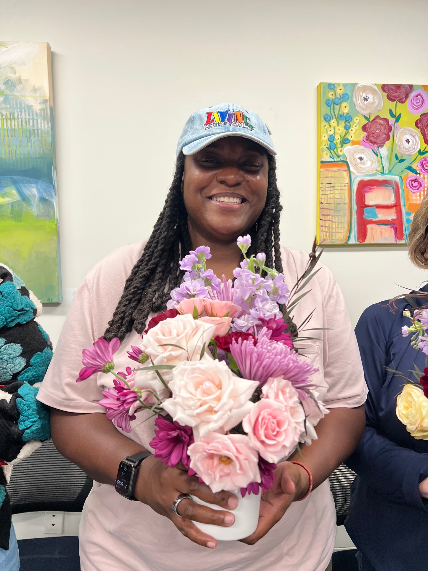 Woman holding a bouquet of flowers with a colorful painting in the background