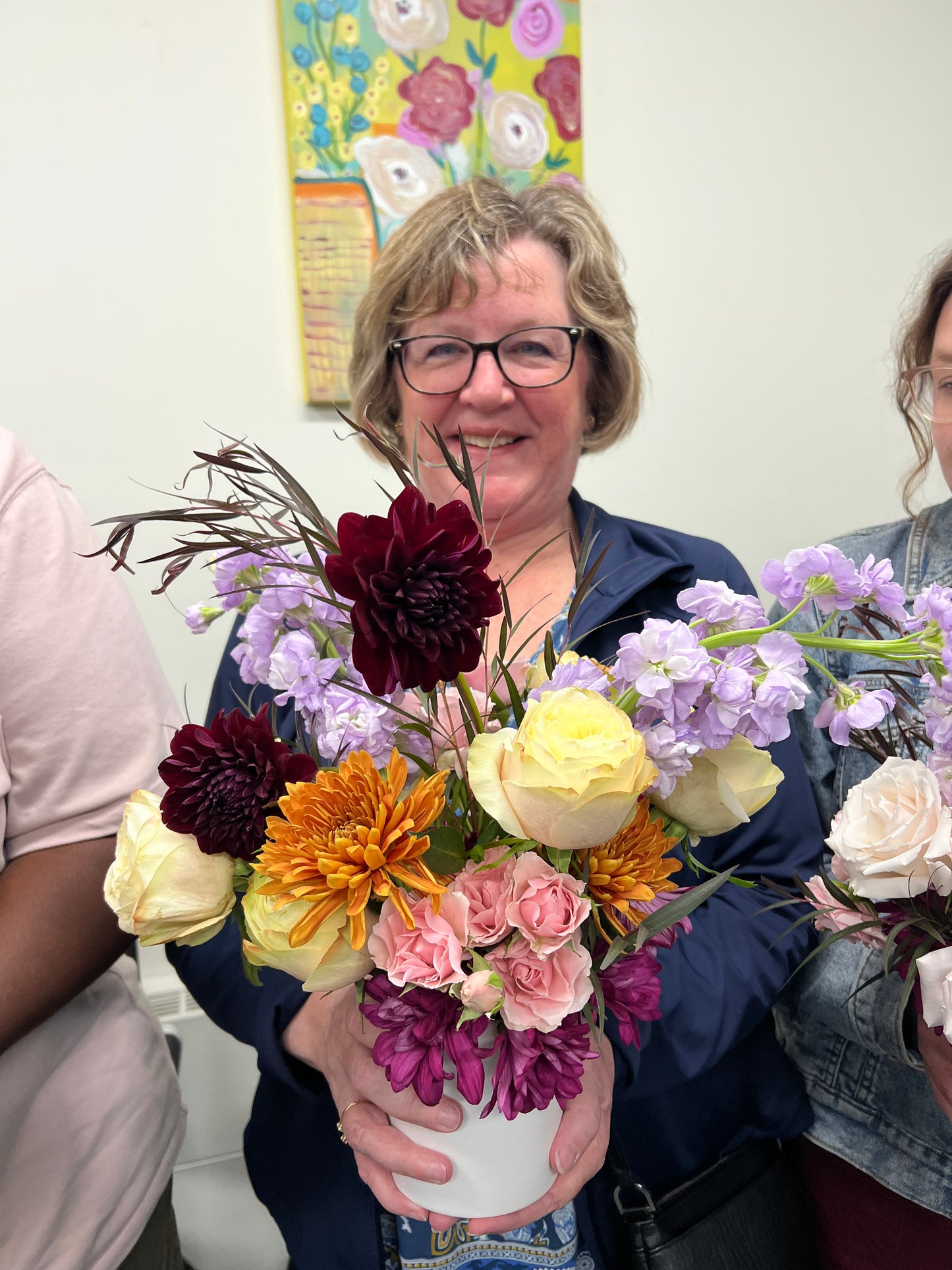 Person holding a colorful bouquet of flowers indoors
